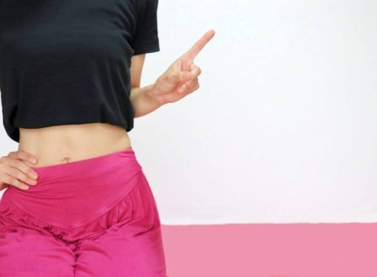 トレーニングウェアを着て指差しをする女性
